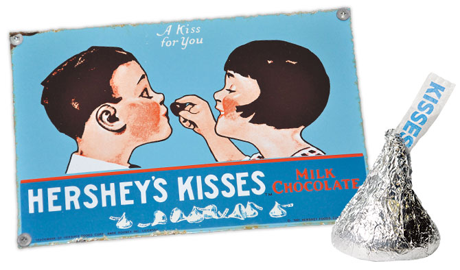 enlargeable vintage ad of a girl feeding a boy a Hershey kiss