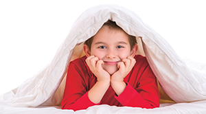 a boy smiles with a blanket over his head