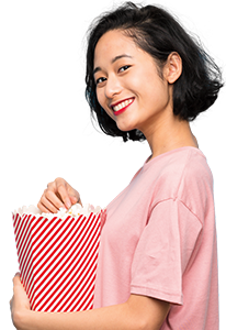 a woman smiling while holding a tub of popcorn