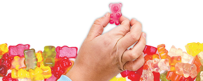 A hand pinching a gummy bear